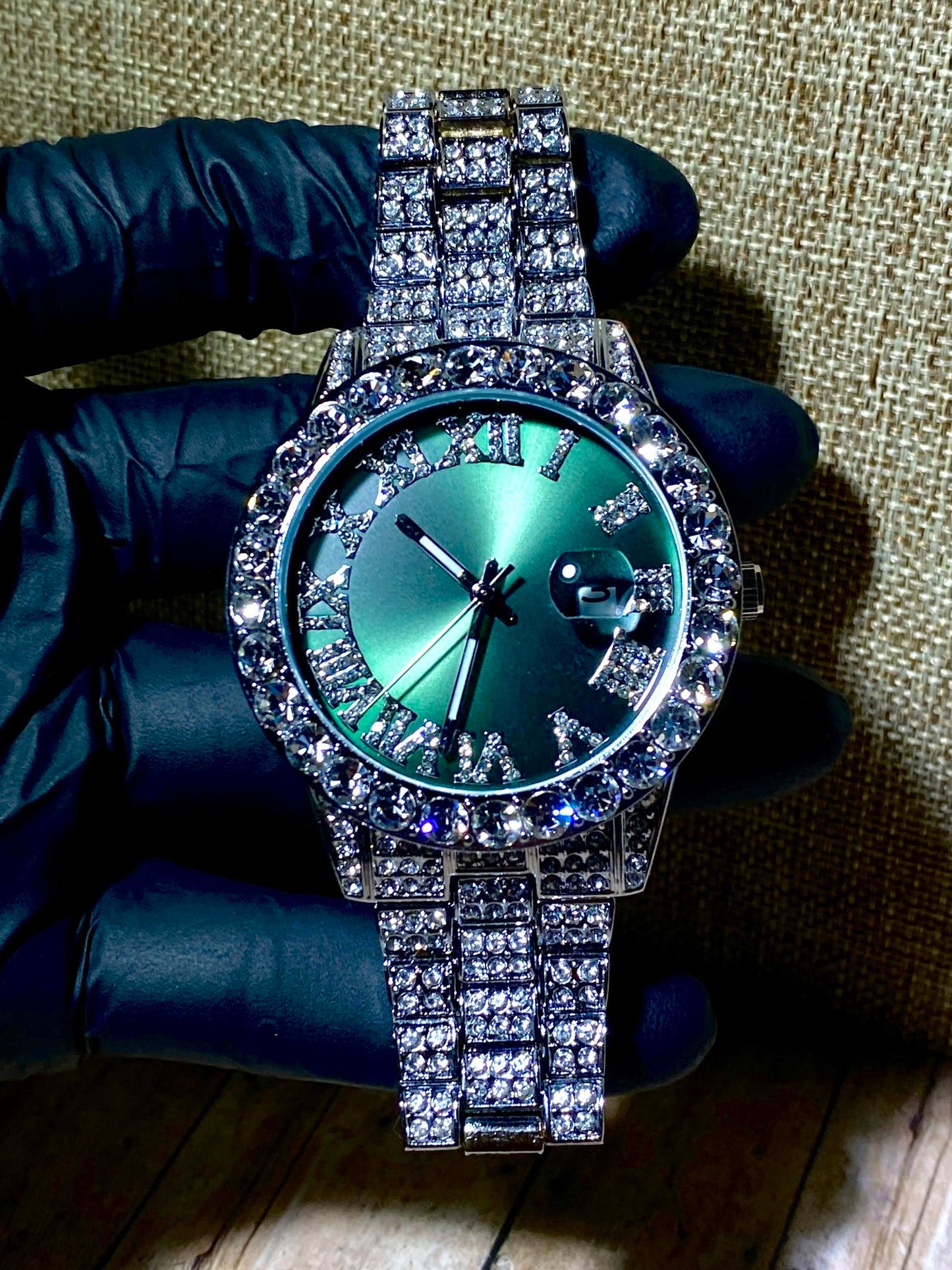Silver iced-out watch with emerald green dial, Roman numerals, and diamond bracelet – luxury streetwear timepiece