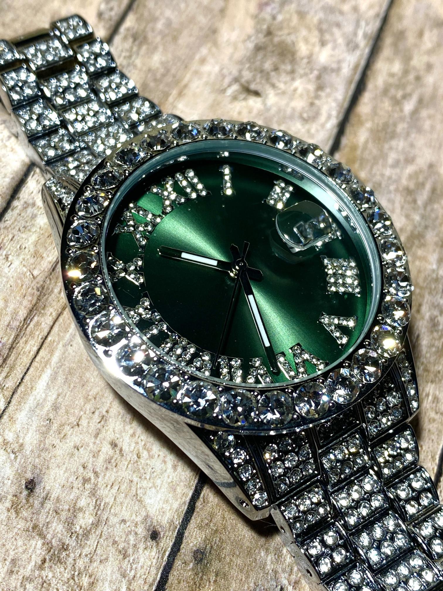 Silver iced-out watch with emerald green dial, Roman numerals, and diamond bracelet – luxury streetwear timepiece
