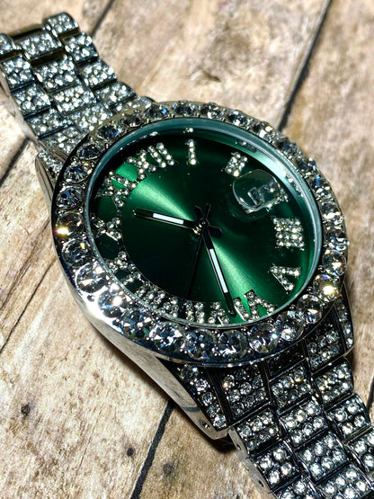 Silver iced-out watch with emerald green dial, Roman numerals, and diamond bracelet – luxury streetwear timepiece