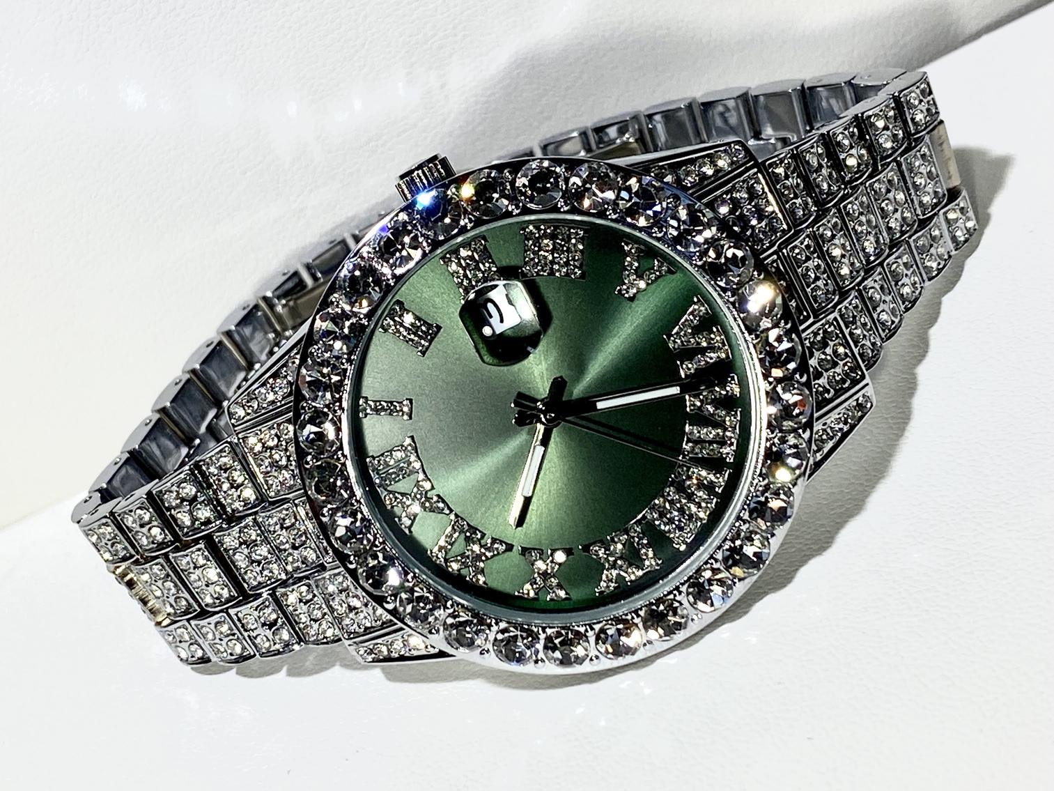 Silver iced-out watch with emerald green dial, Roman numerals, and diamond bracelet – luxury streetwear timepiece