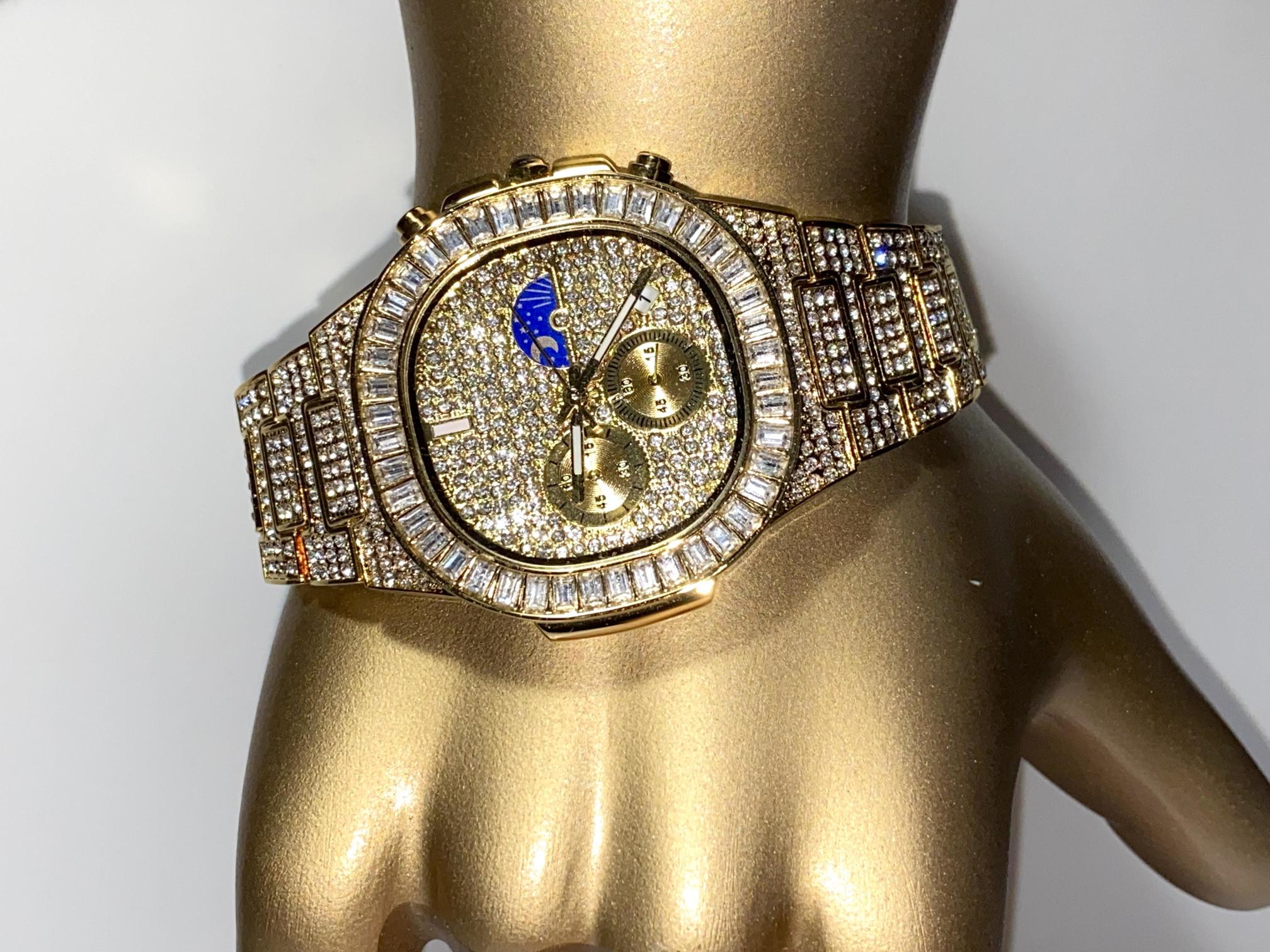Gold-tone unisex watch with a diamond-studded dial and bezel. The watch features dual sub-dials, a moonphase display, and a sparkling crystal-encrusted band, offering a luxurious and high-end look.
