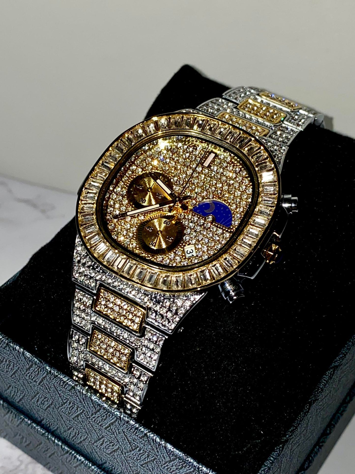 Two-tone iced-out watch with gold dial, moon phase complication, and baguette bezel – luxury diamond timepiece