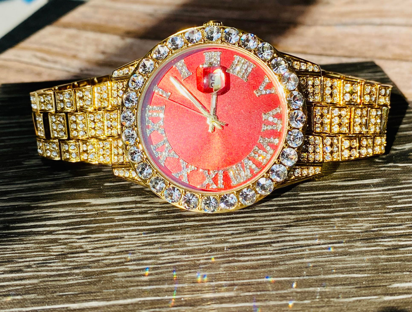 Gold iced-out watch with scarlet red dial, Roman numerals, and diamond bracelet – luxury streetwear timepiece
