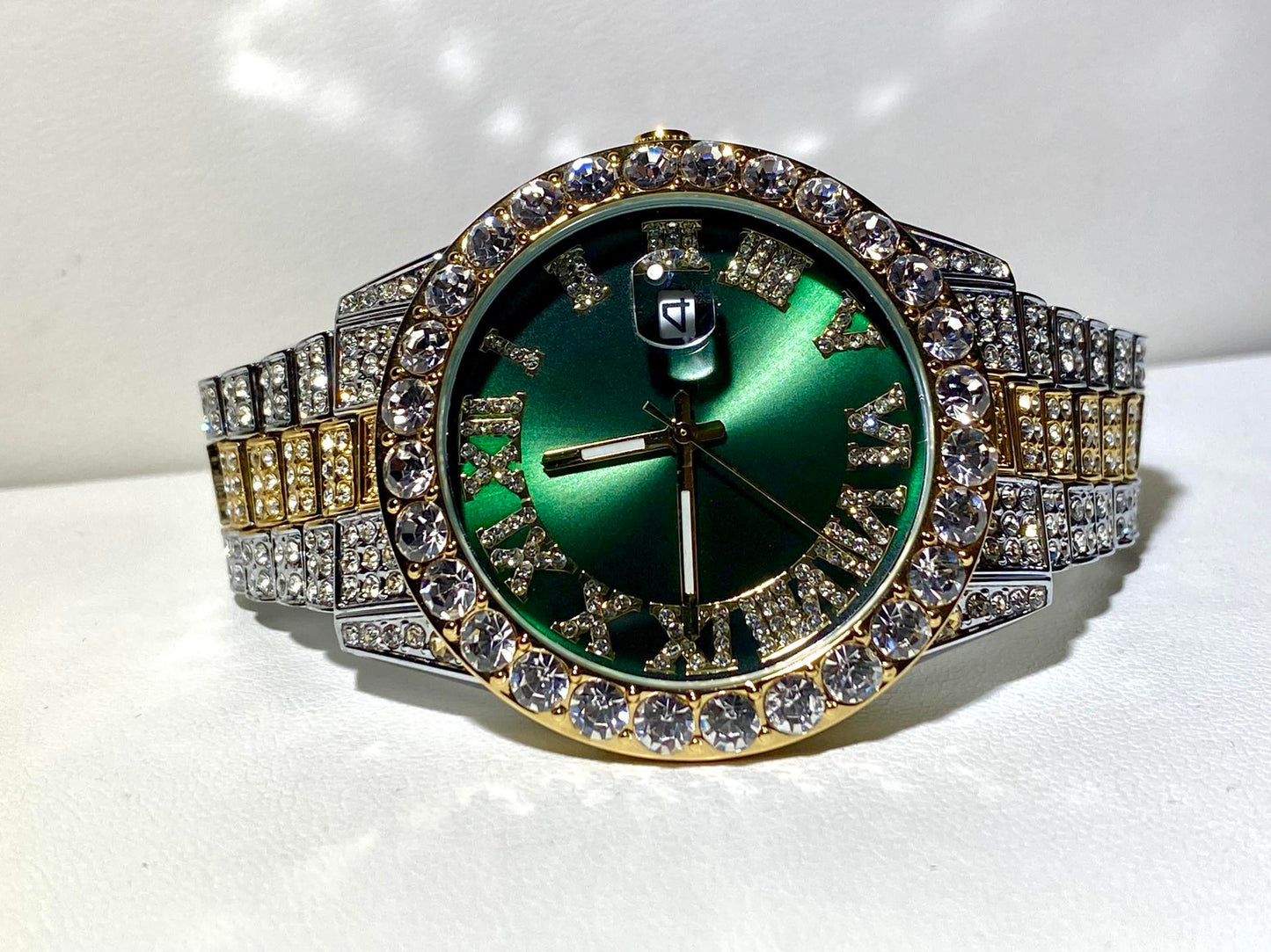 Two-tone iced-out watch with green Roman numeral dial and crystal bezel – luxury statement timepiece
